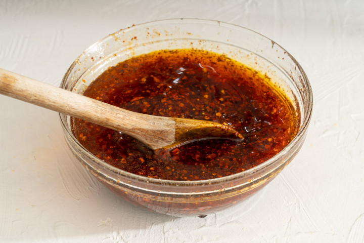 Freshly made garlic chili oil in a small glass bowl.