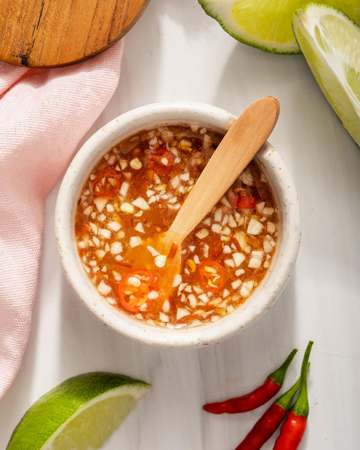Looking down at a small serving jar of nuoc cham Vietnamese dipping sauce.