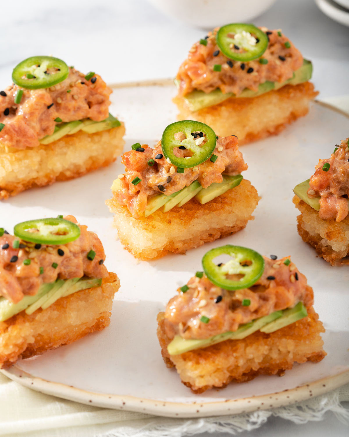 A plate of rice crisp topped with spicy tuna for an appetizer.