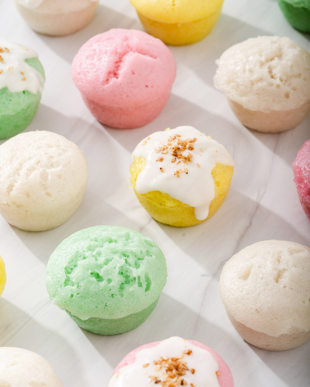 Looking down at a grid of colorful Vietnamese steamed rice cakes.