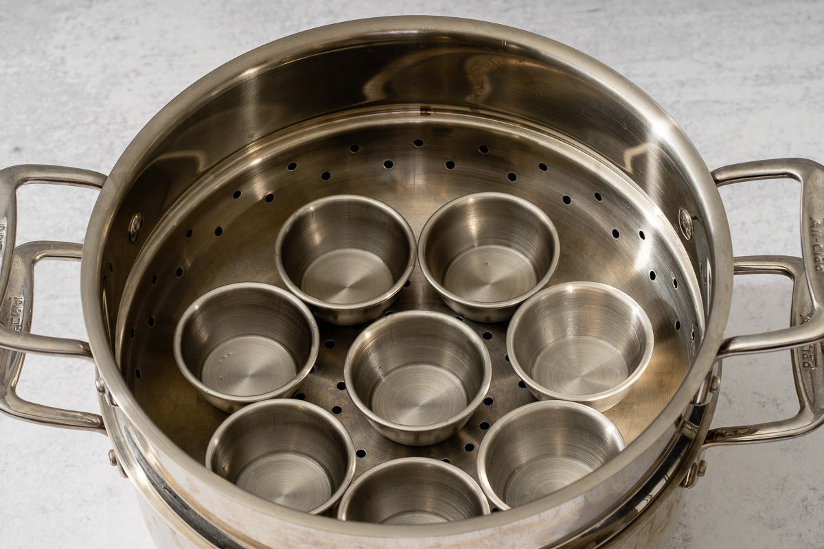 A steamed with mini round tins for steaming the Bánh Bò Hấp.