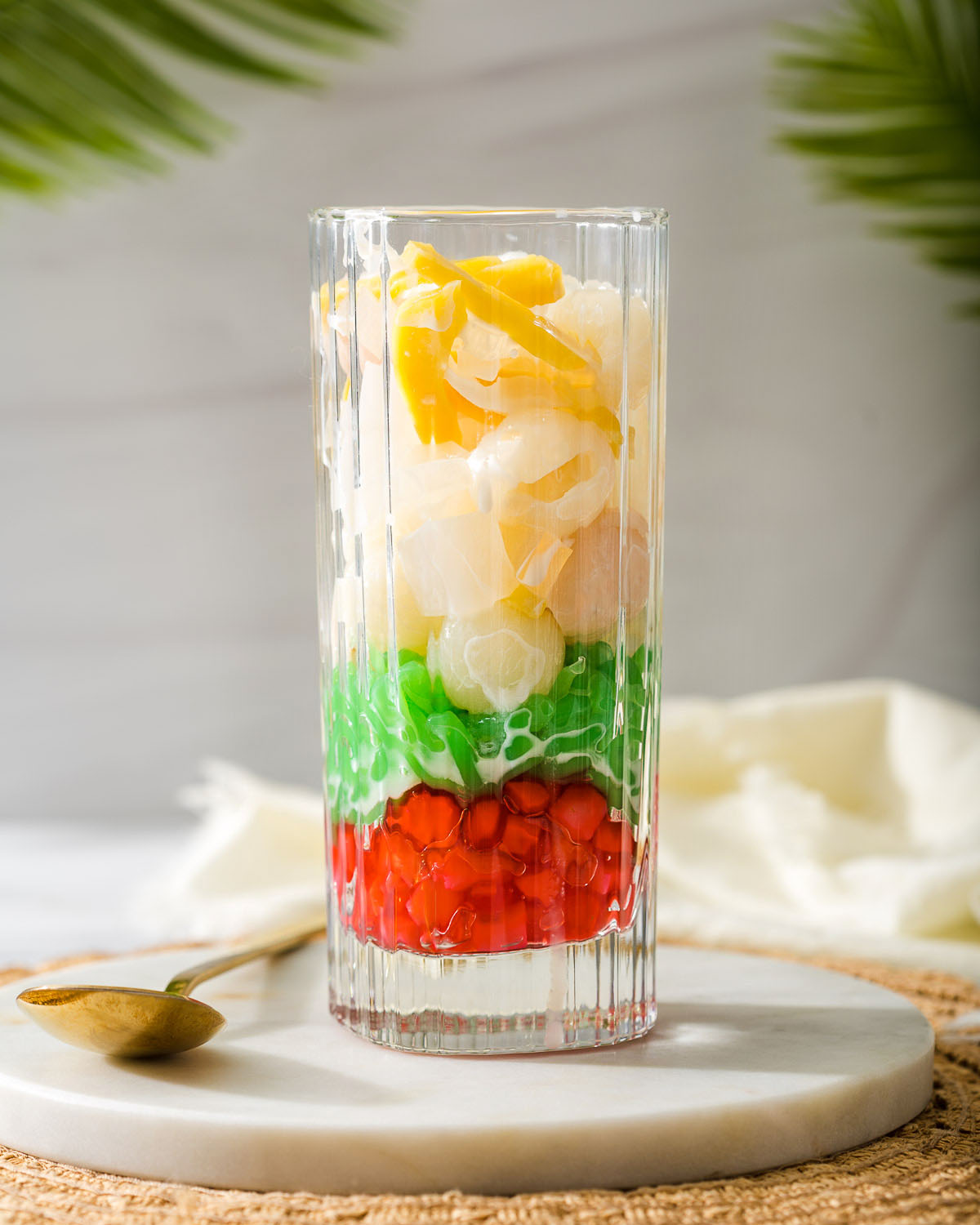 Layers of fruit in a tall glass to make che thai.