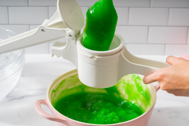 Filling a ricer with pandan jelly to make pandan worms.