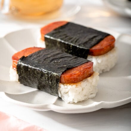 Up close of two spam musubis sitting on a plate.