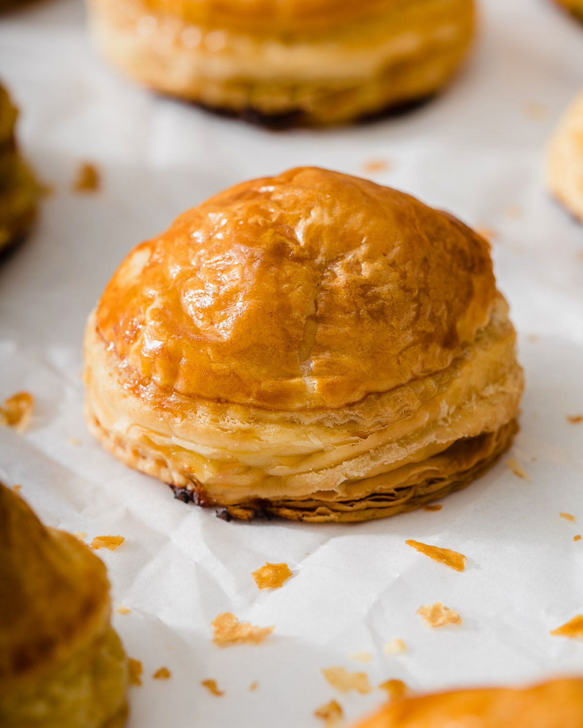 Up close of a vietnamese banh pate so sitting on parchment paper.