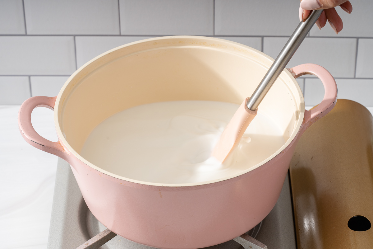 Heating the coconut mixture in a small pot.