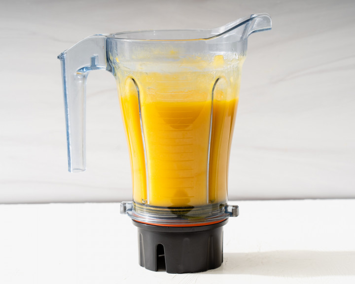Mango pureed with sugar inside a blender.