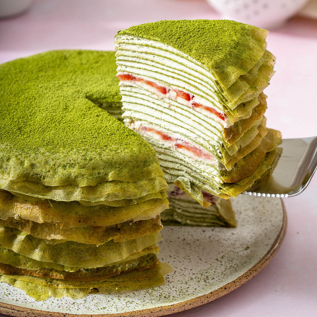Up close of a slice of cake being lifted from a matcha crepe cake.