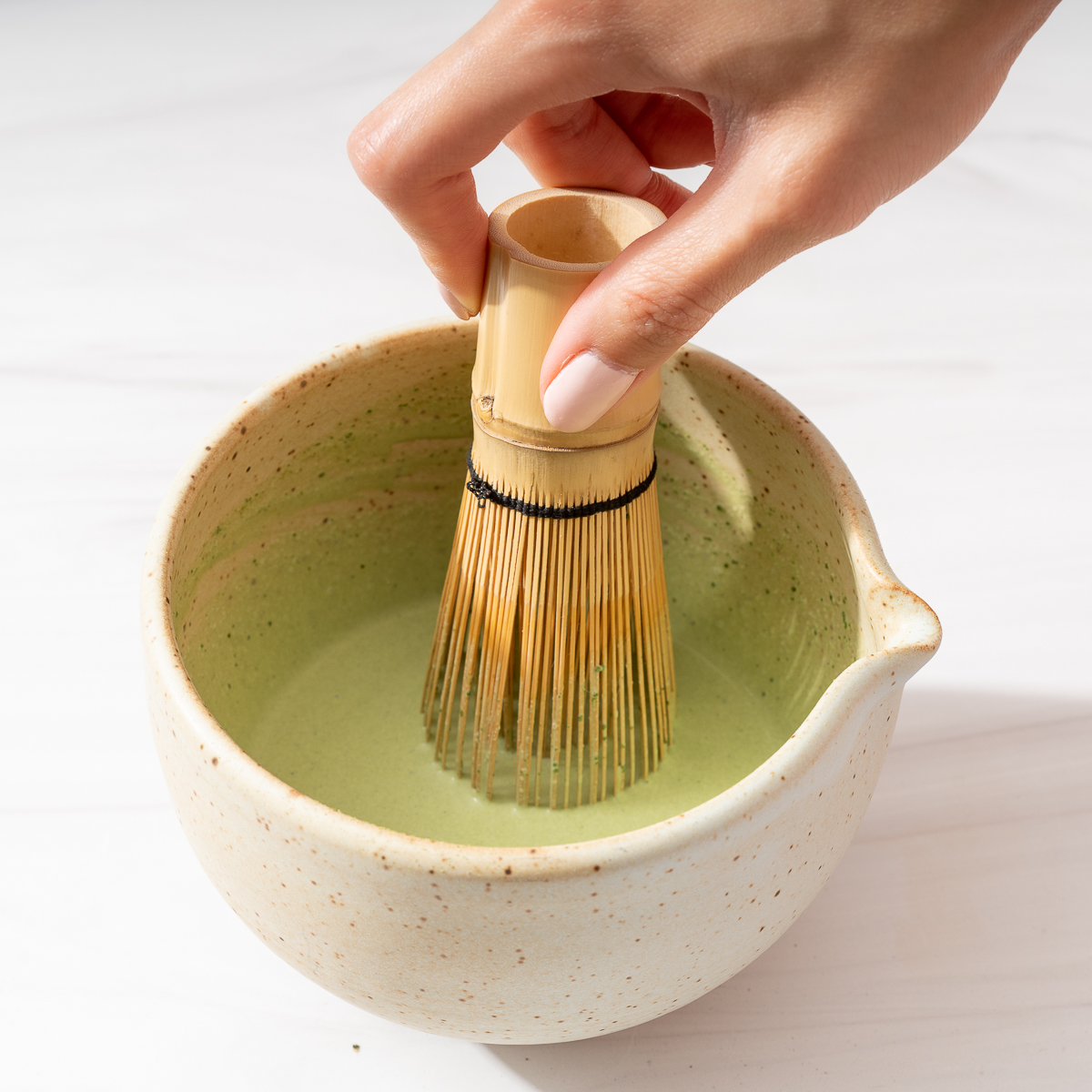 Whisking together matcha in a bowl.