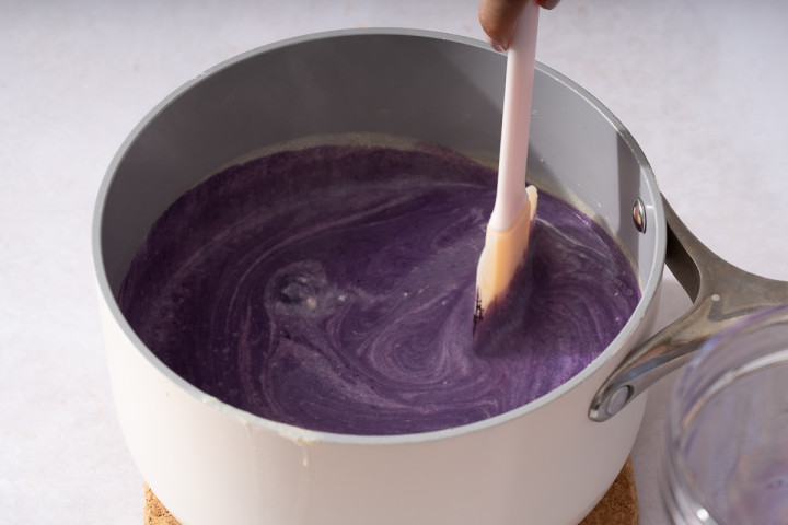 Mixing the ube and cream to combine.