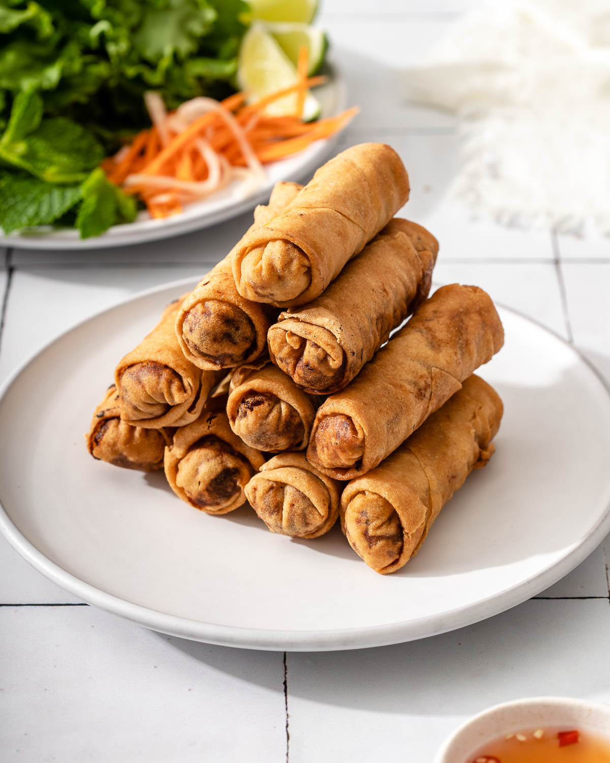 A plate with a stack of vietnamese egg rolls.