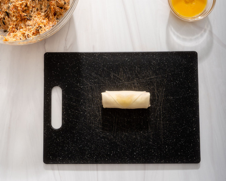 A completed egg roll ready to fry.