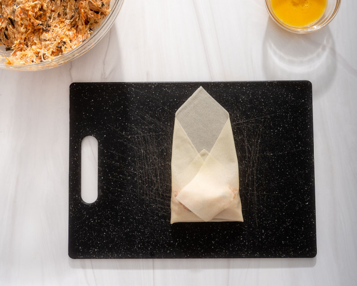 Tucking in the sides of the wrapper.