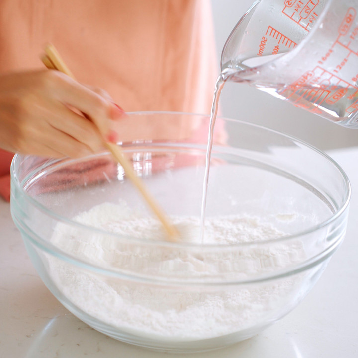 Adding hot water to a bowl of flour and salt.