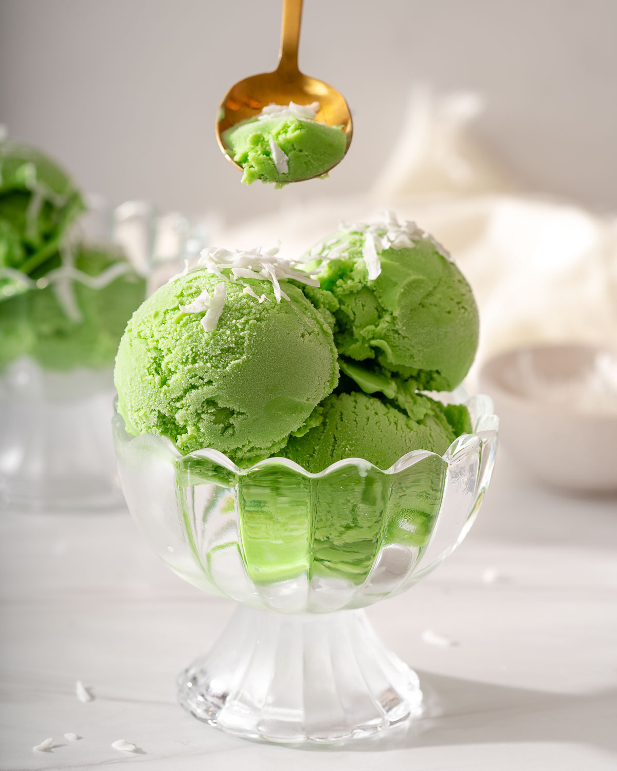 Scooping pandan ice cream from a small serving bowl.