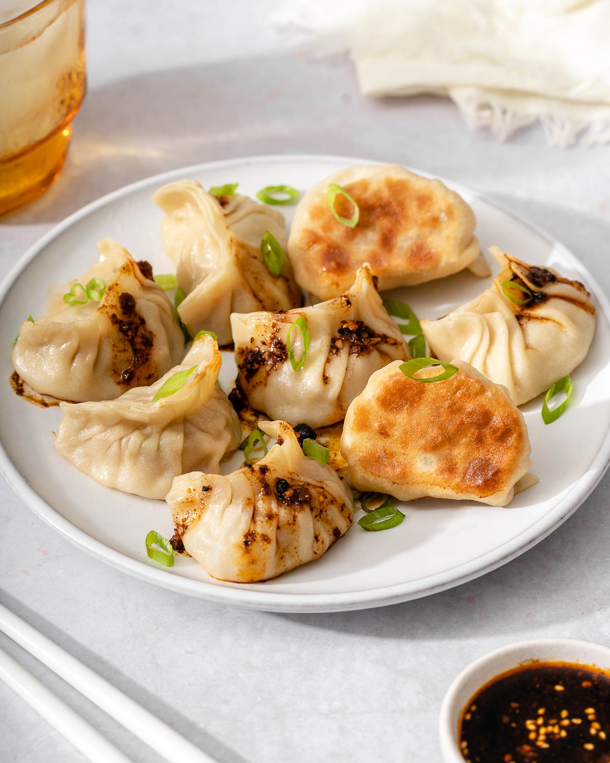 A plate of pork and cabbage dumplings garnished.