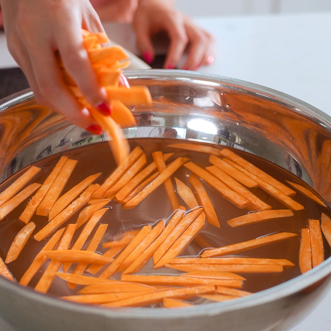 Soaking carrots chopped into match sticks in a bowl of cold water.
