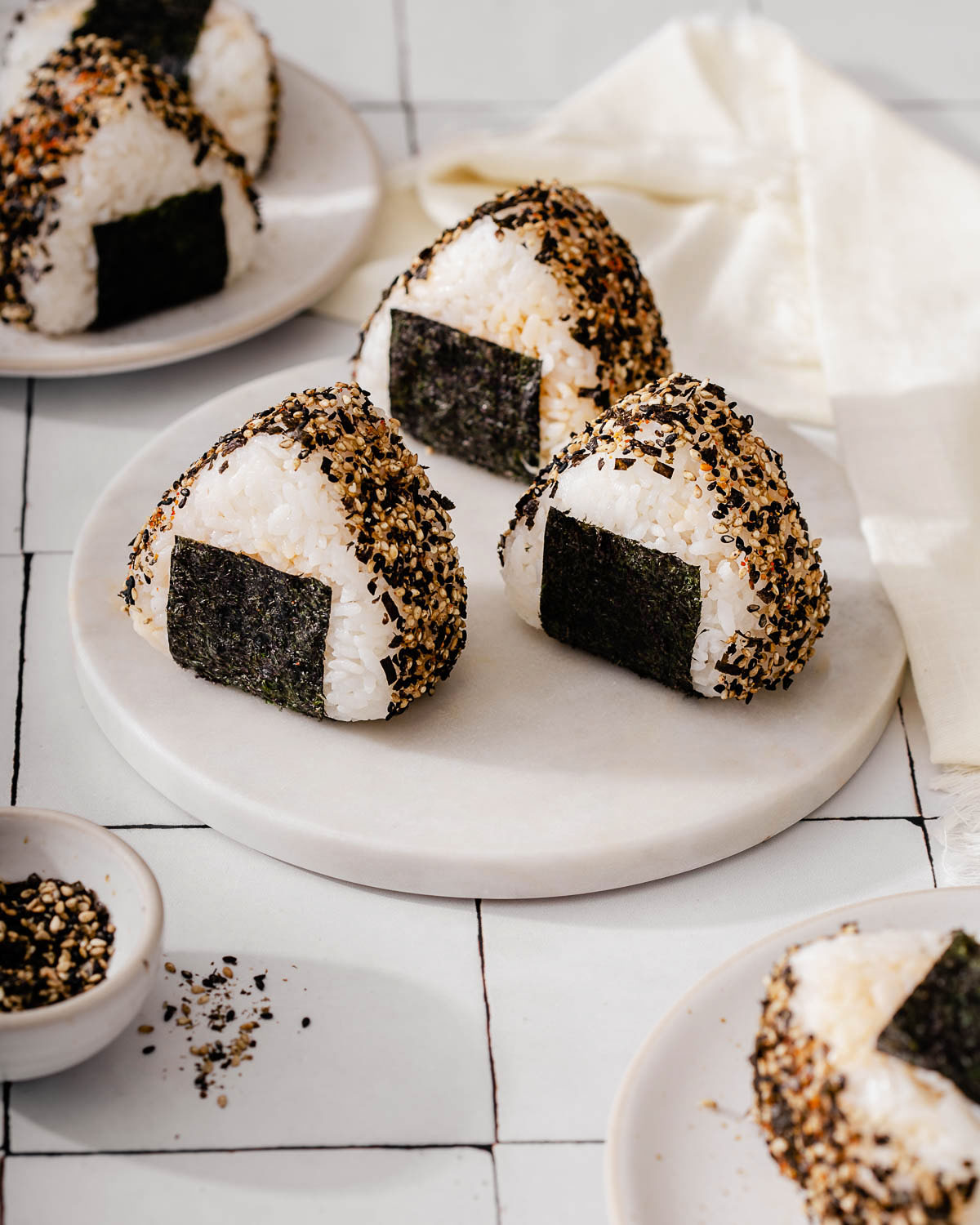 A couple tuna onigiri sitting on a serving platter.