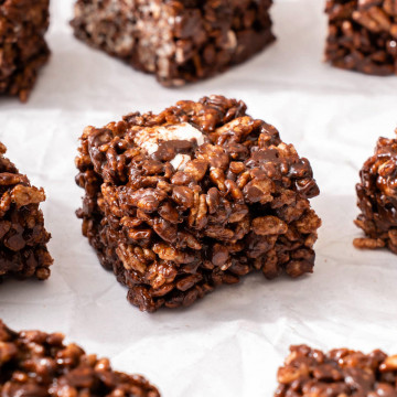 Up close of a chocolate rice krispie treat on parchment paper.