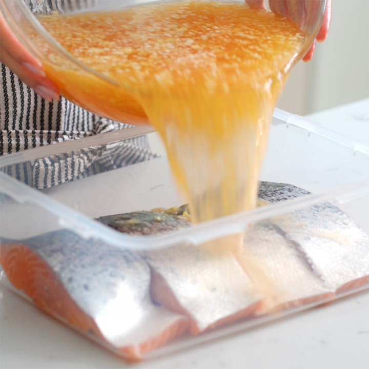 Pouring the brine into a tupperware with salmon to soak.
