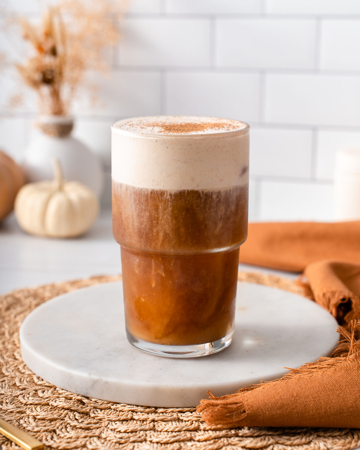 A glass of cold brew topped with pumpkin foam and pumpkin spice.