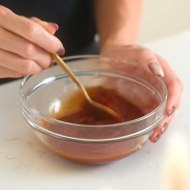 Mixing together katsu sauce in a small mixing bowl.