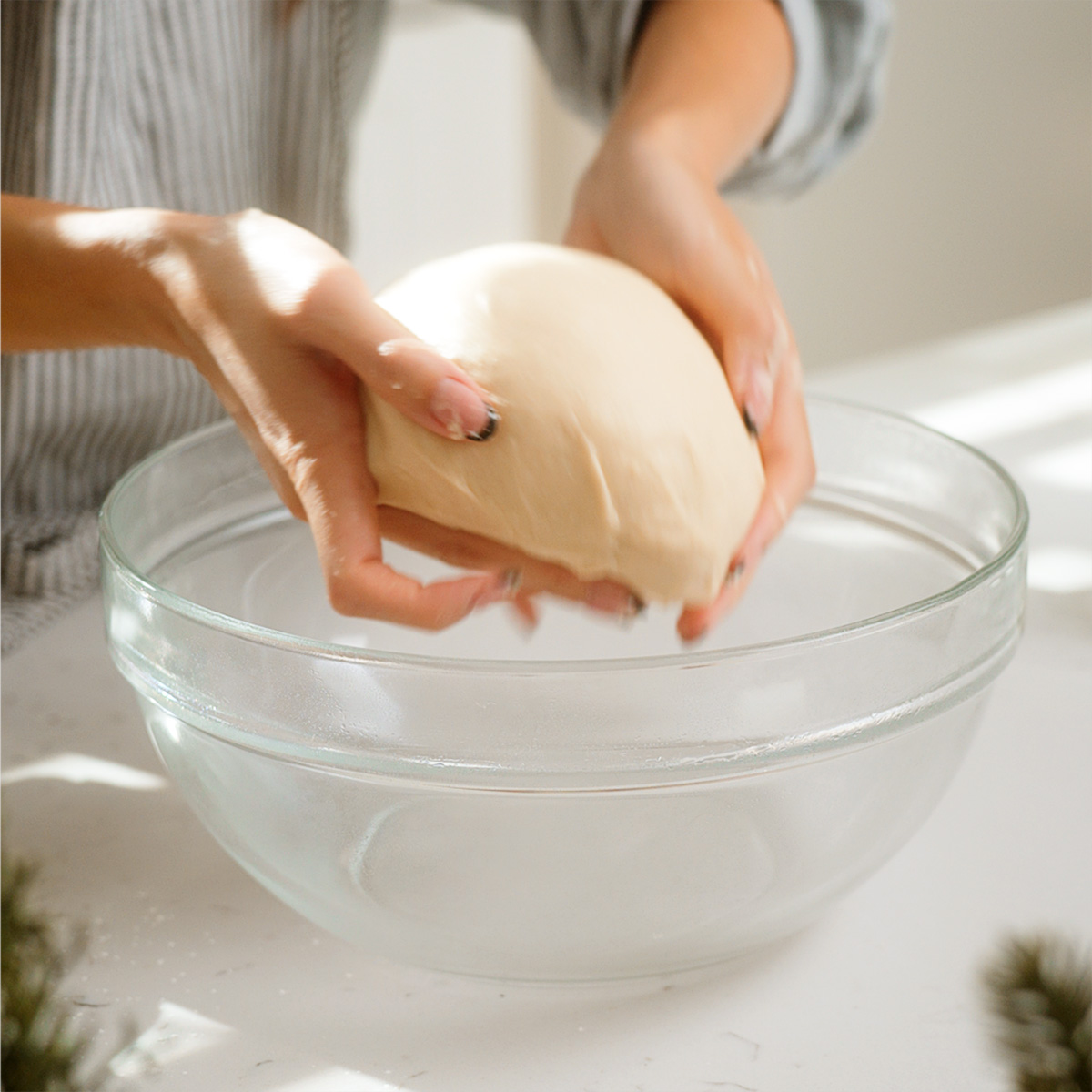 Placing the dough into a bowl to prepare for proofing.
