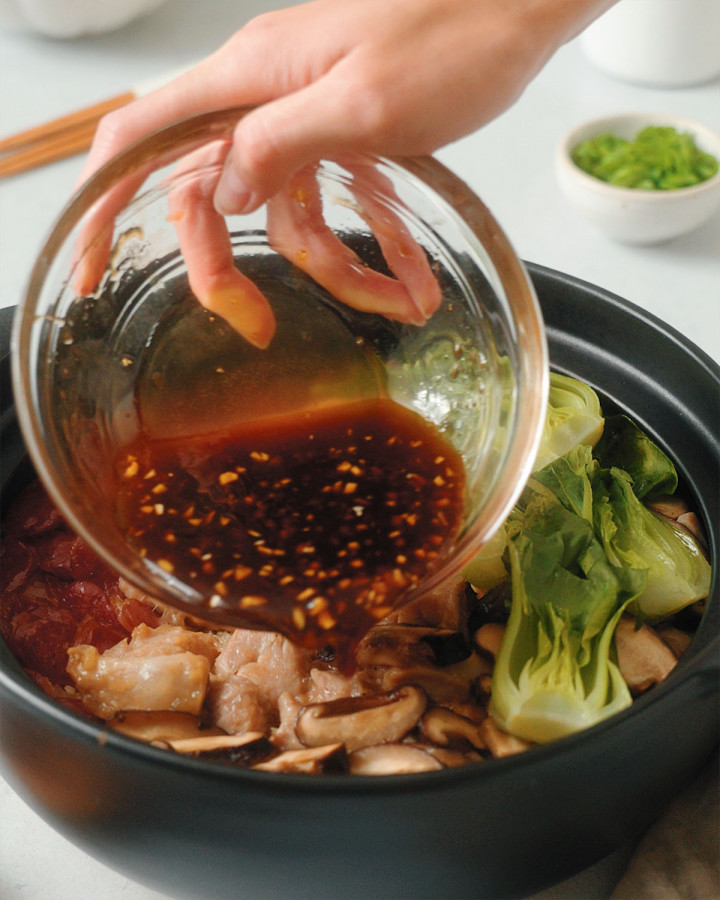 Pouring the final sauce onto the clay pot rice.