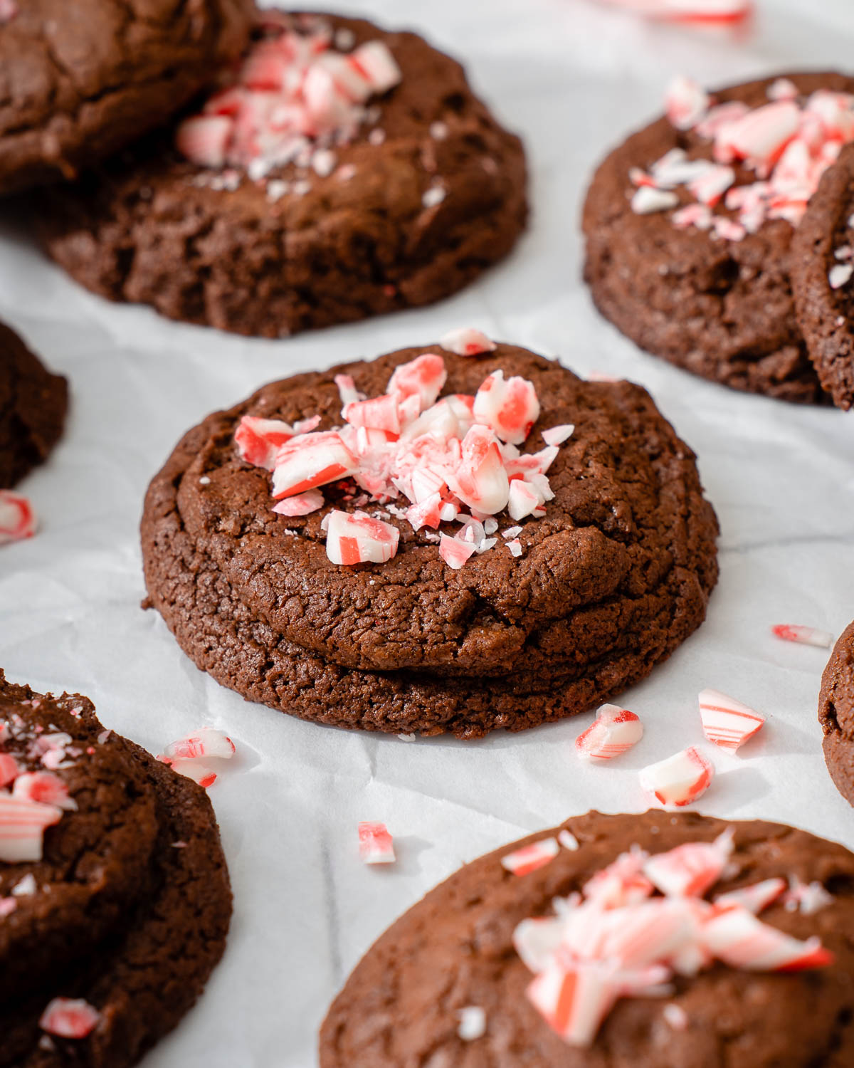 Fudgy peppermint brownie cookies sitting on parchment paper.