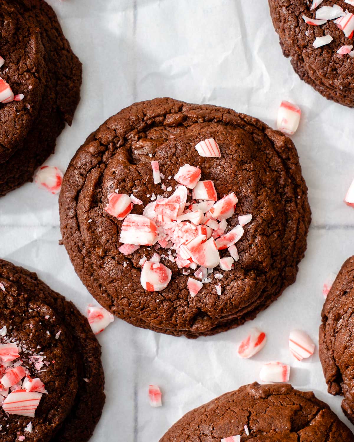 Looking down at a grid of fudgy peppermint brownie cookies sitting on parchment paper.