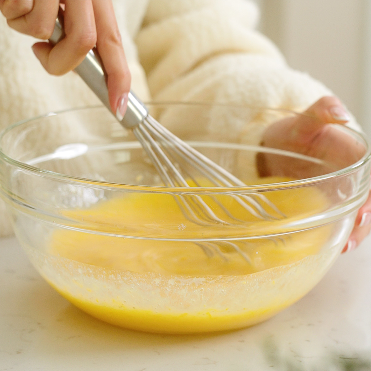Mixing together all of the wet ingredients in a mixing bowl with a whisk.