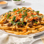 Up close with a plate of bulgogi fries surrounded by table settings.