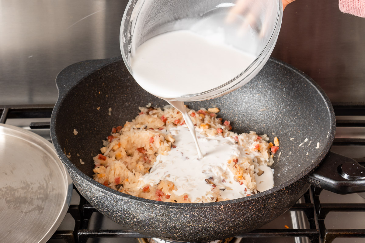 Adding the batter to the Chinese turnip cake mixture in the wok.
