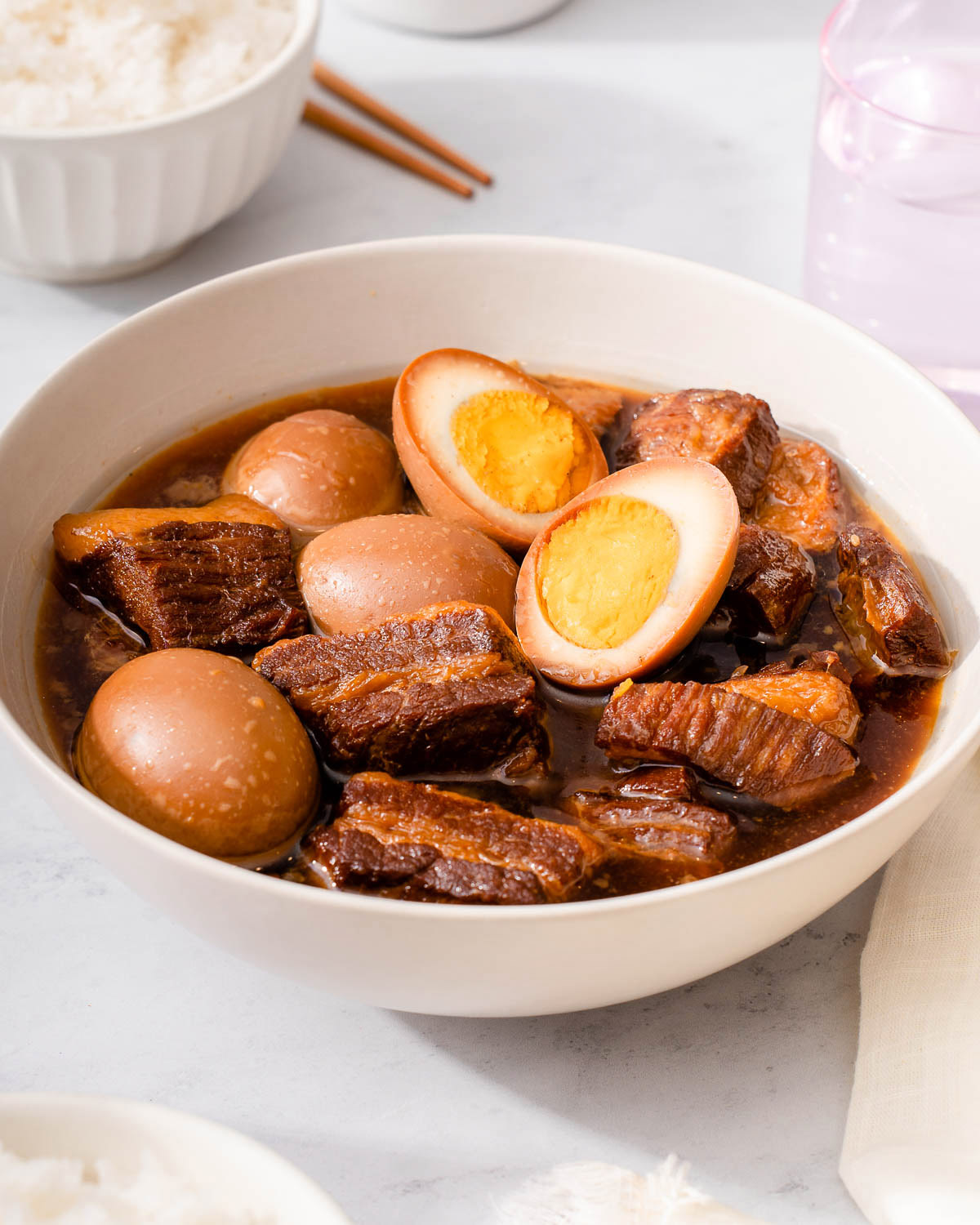 A bowl of Vietnamese braised pork belly and eggs on a table.