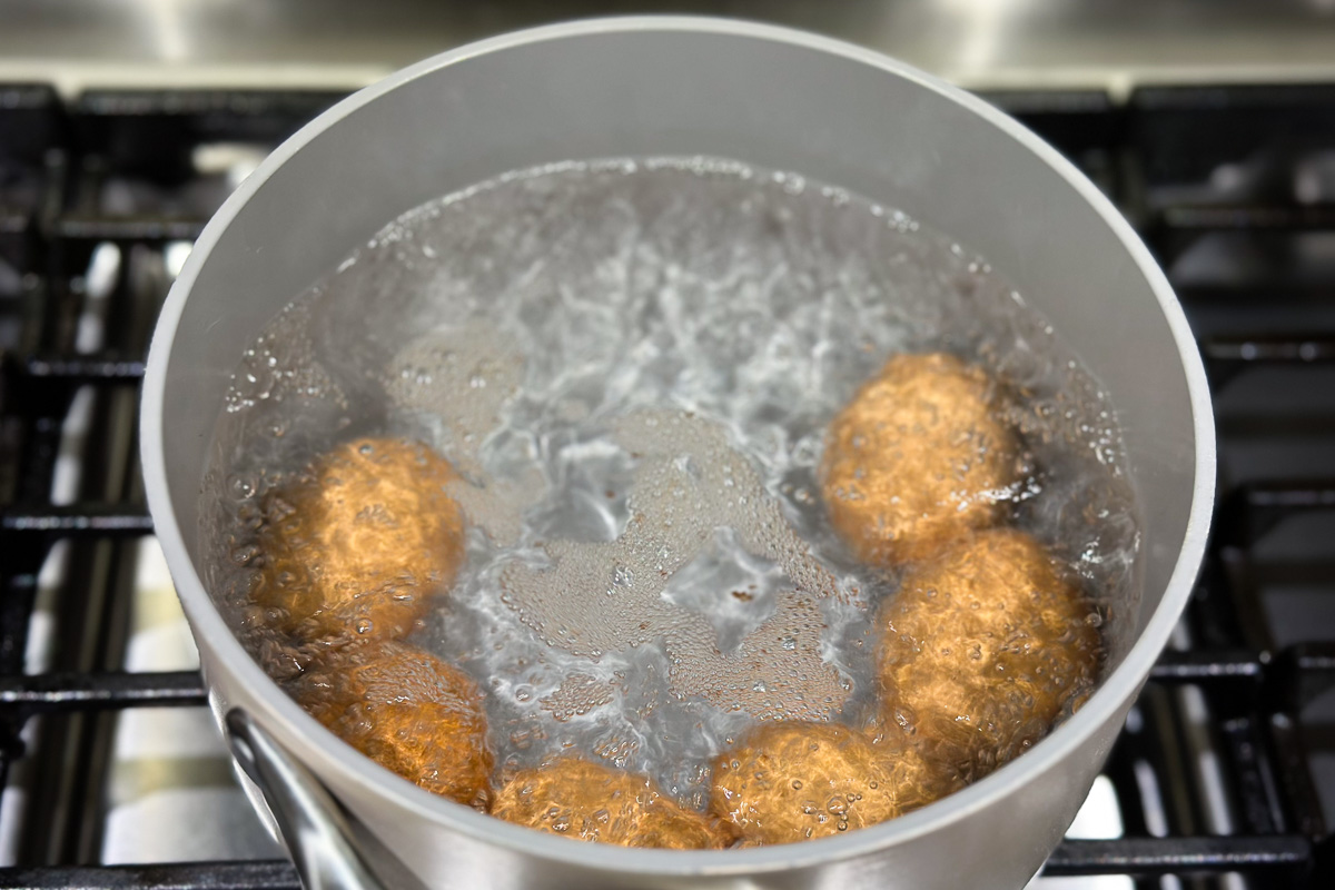 Boiling large eggs in a pot of water.