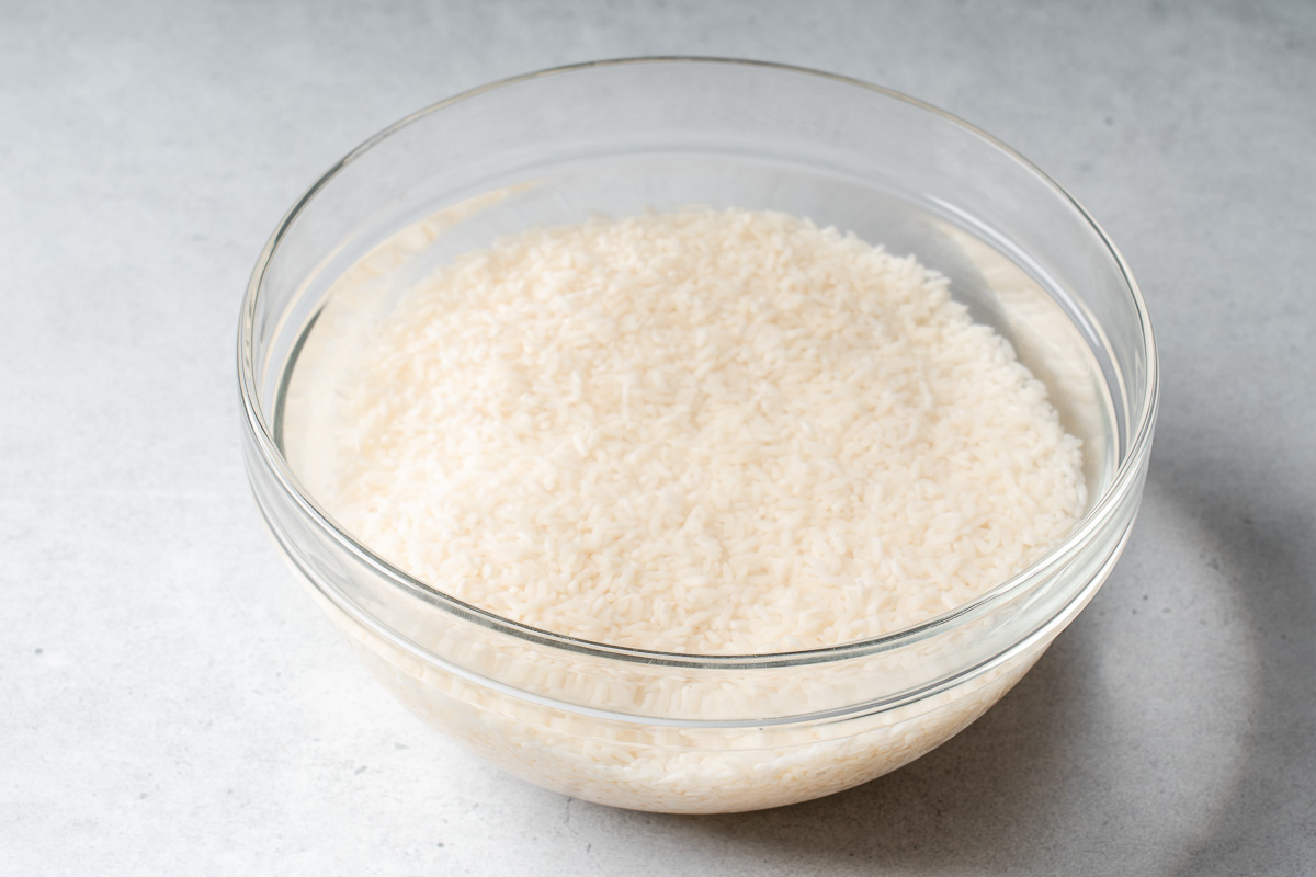 A bowl of sticky rice soaking in water.