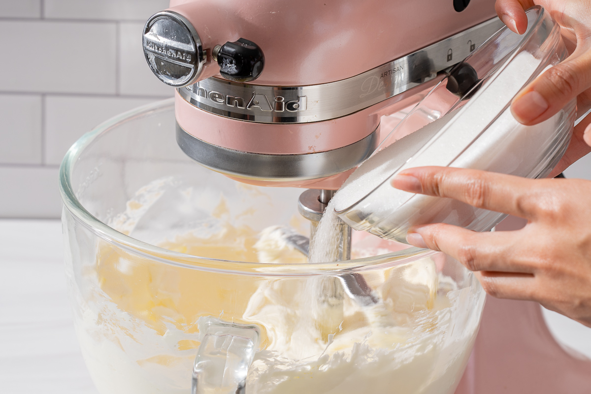 Adding sugar to the creamed cream cheese.