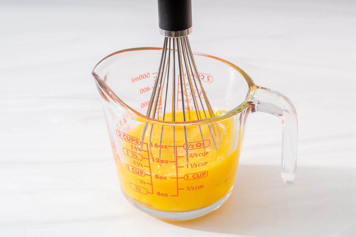 Lighting whisked eggs in a large measuring cup.