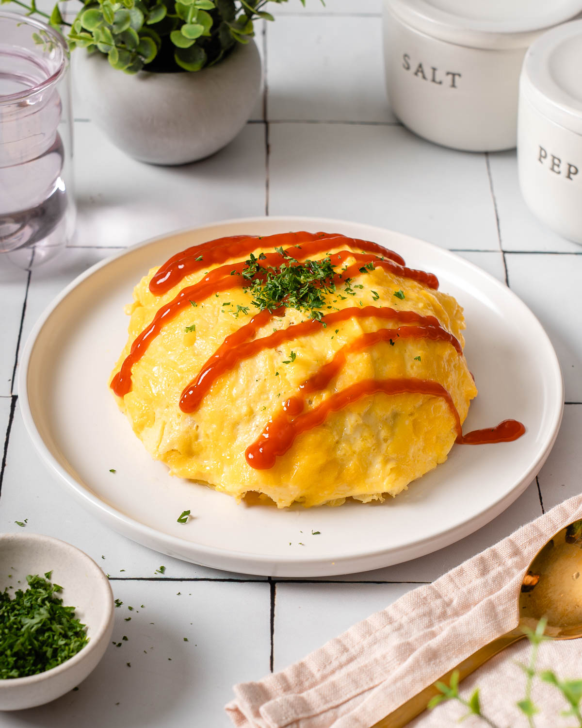 A plate with an omurice japanese rice omelete on it garnished and ready to eat.