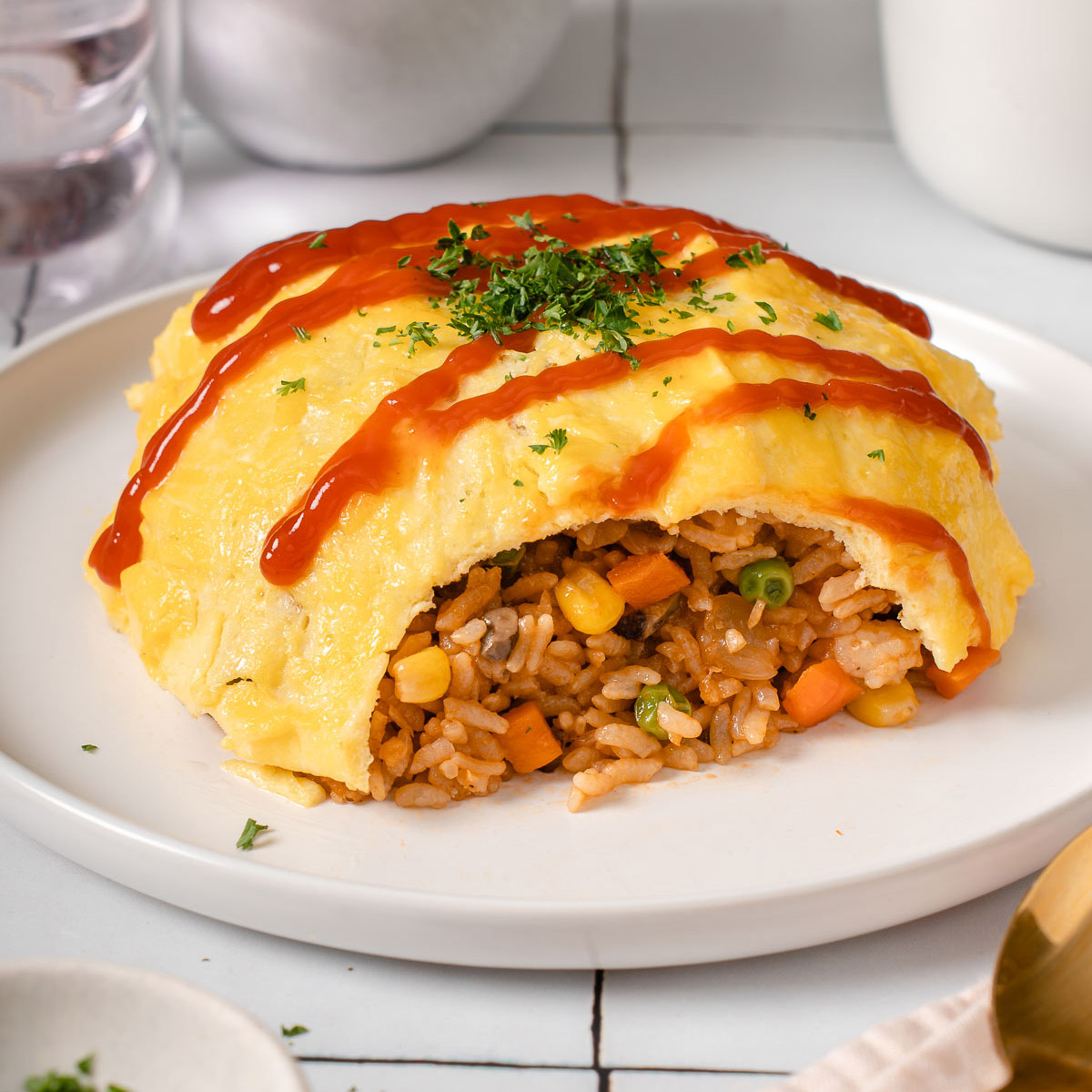 Up close with a plate of omurice cut open to show the fried rice inside.