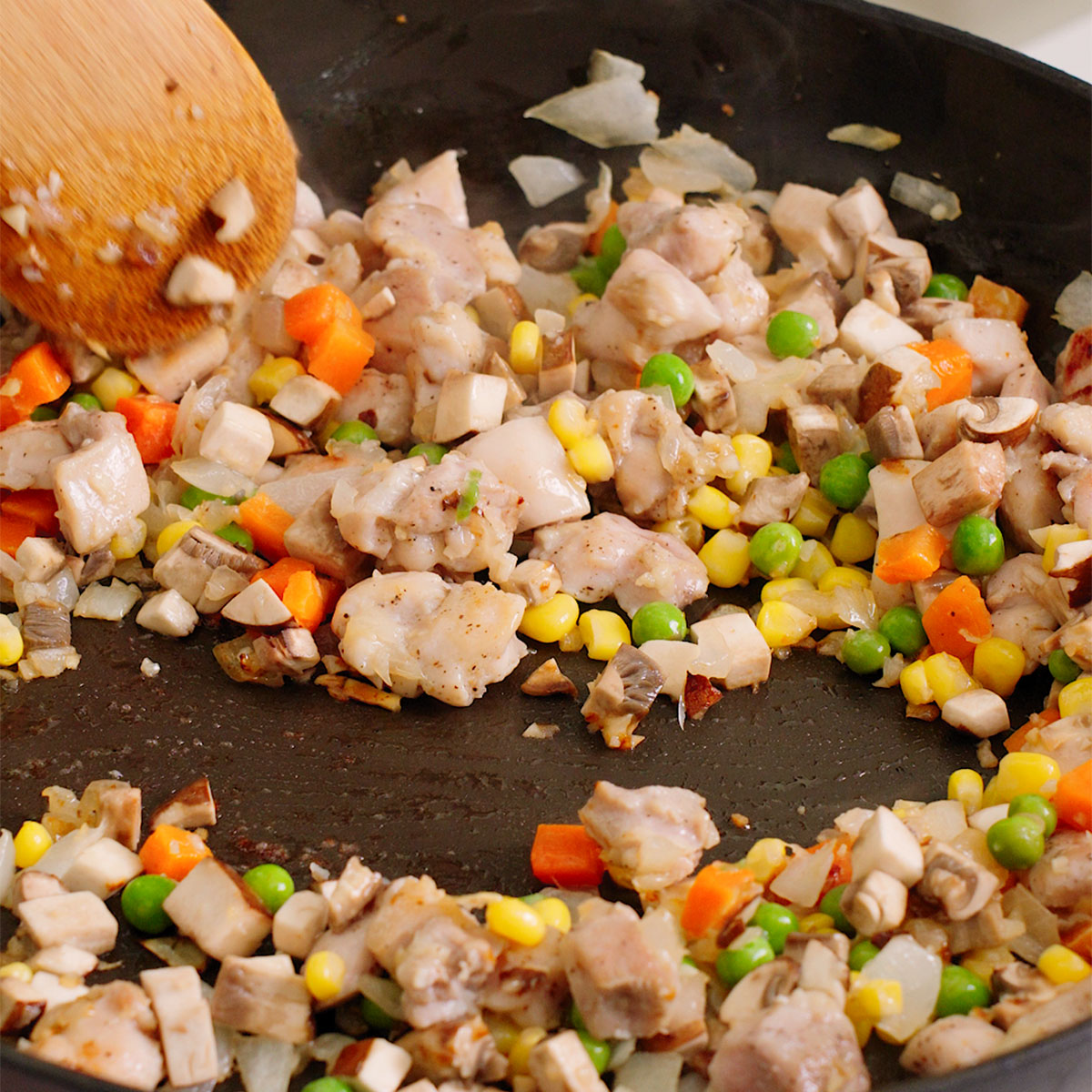 Cooking the frozen vegetables and mushrooms in the large skillet.