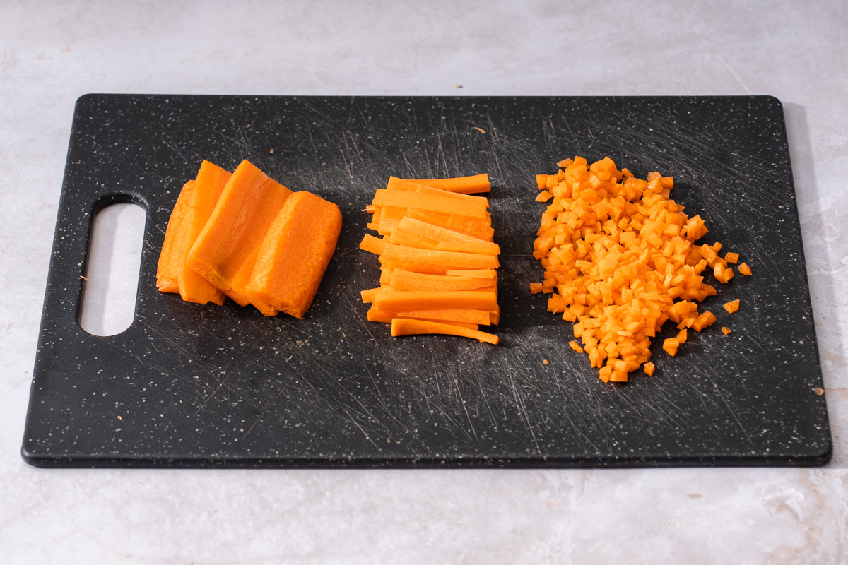 The step by step breakdown of slicing a carrot until finely minced.