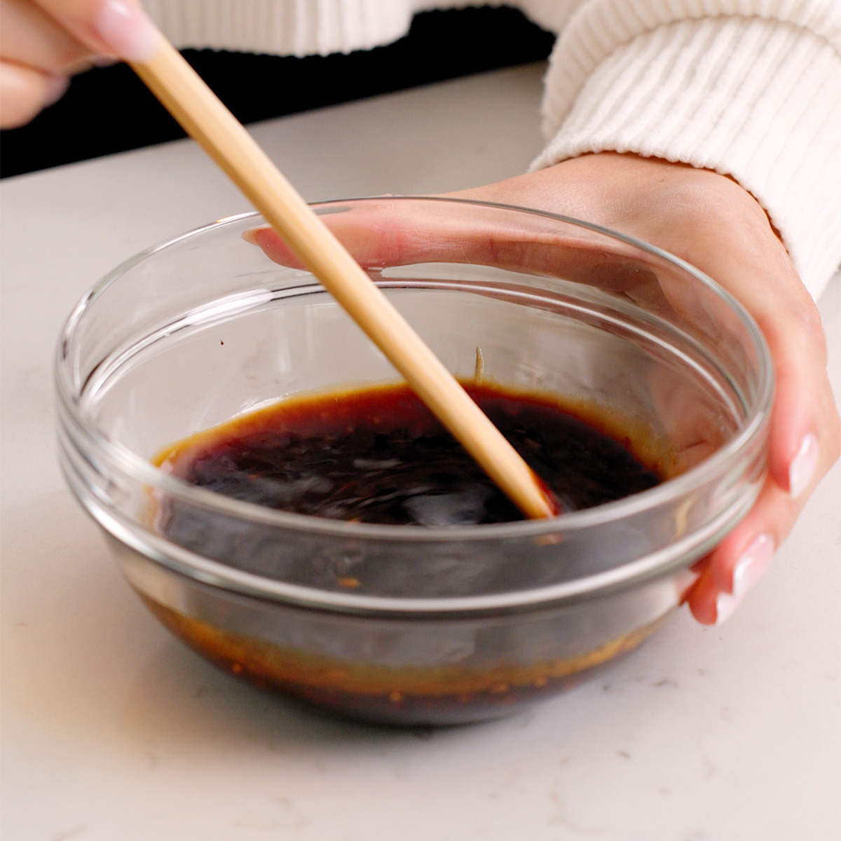 Mixing together yaki udon sauce in a small glass bowl.