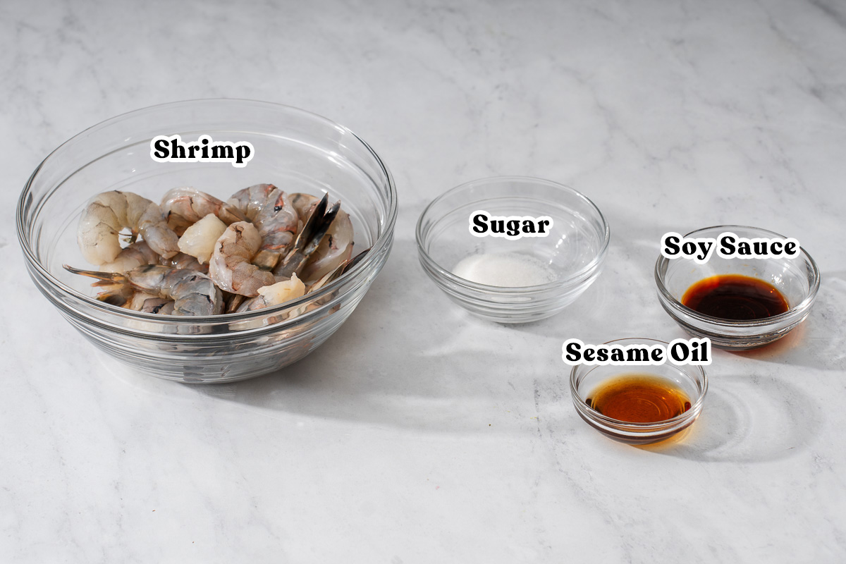 The shrimp and marinade ingredients for bihun goreng organized and labeled.
