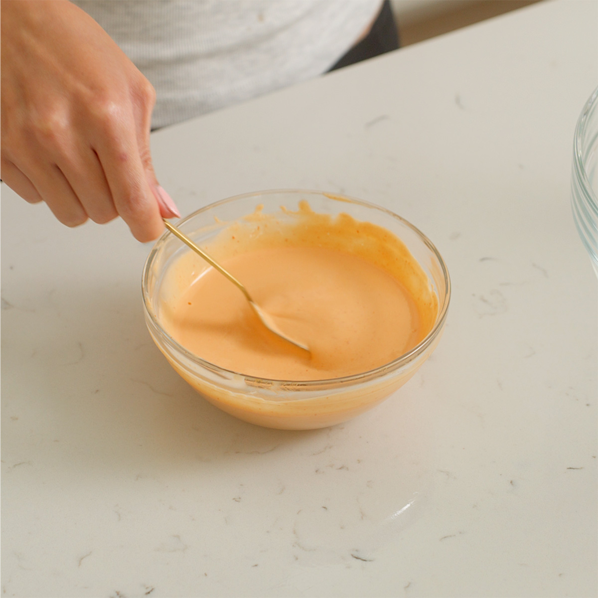 Mixing together spicy mayo in a small bowl.