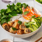 Up close with a bowl of vietnamese egg rolls with vermicelli noodles.