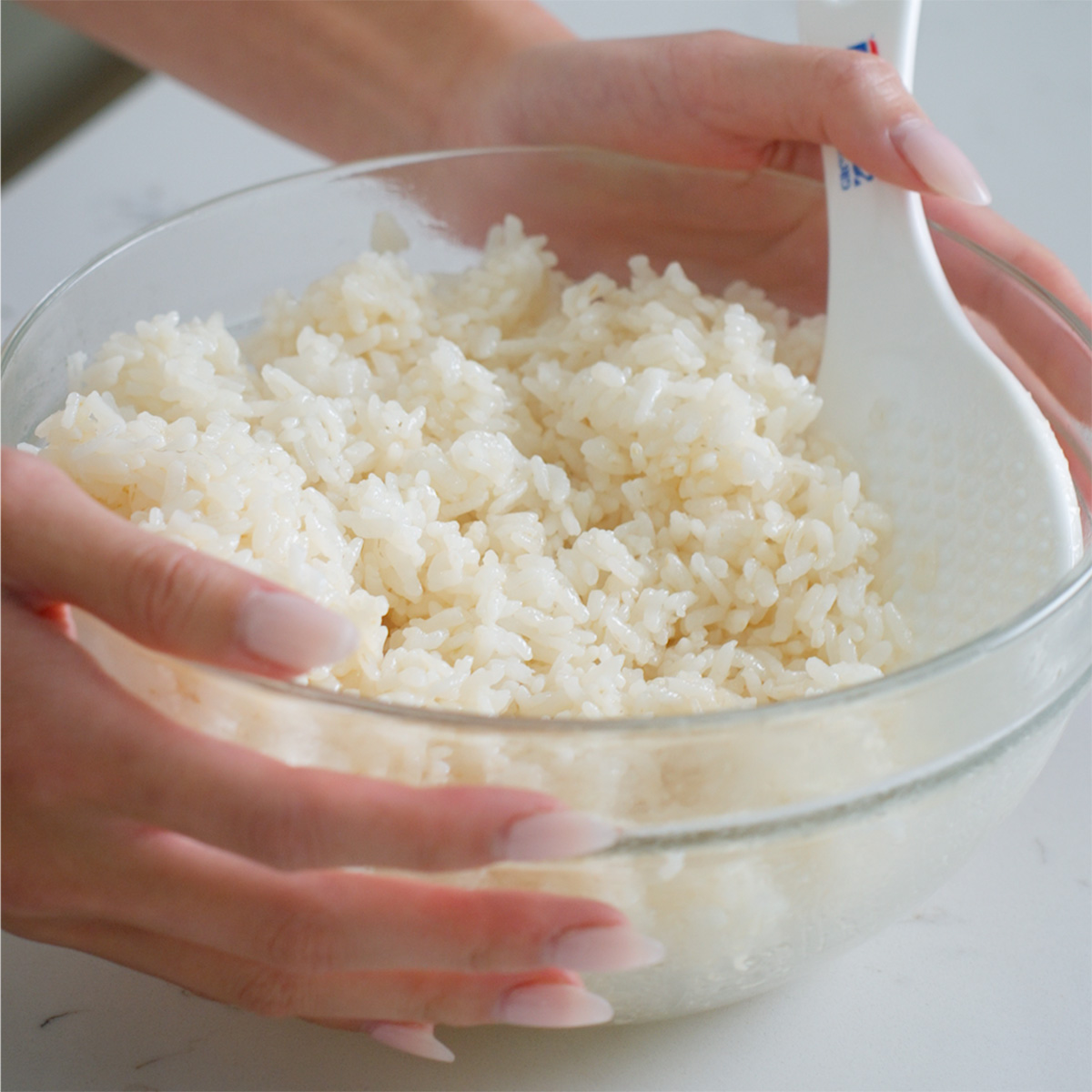 A glass bowl of korean seasoned rice for making rice balls.