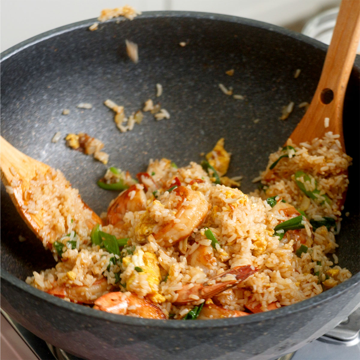 Thai fried rice mix together inside a large wok.