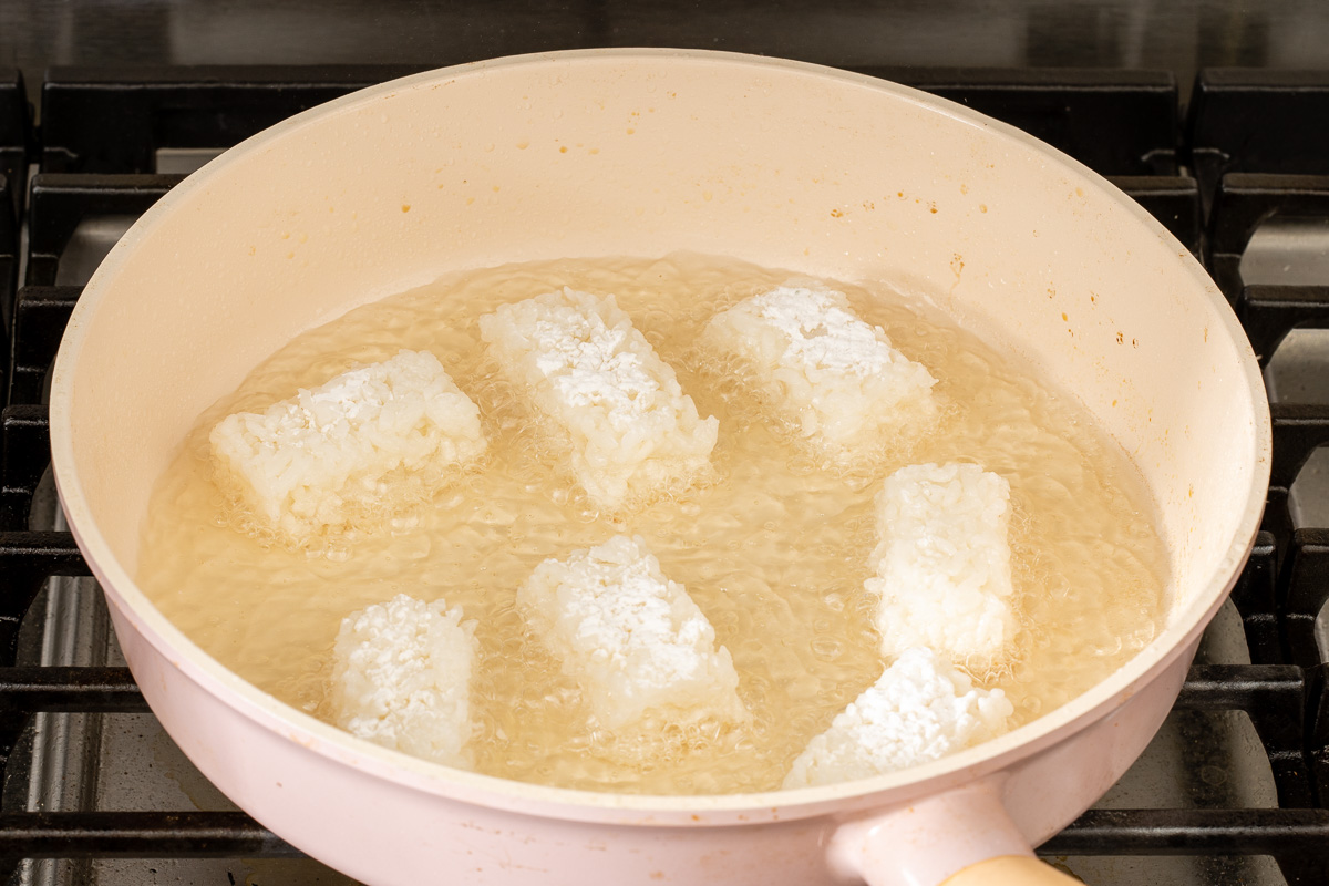 Crispy rice shallow frying in a pan.