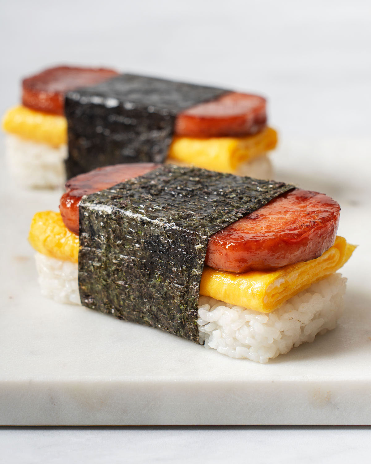 Up close with a egg spam musubi on a cutting board.